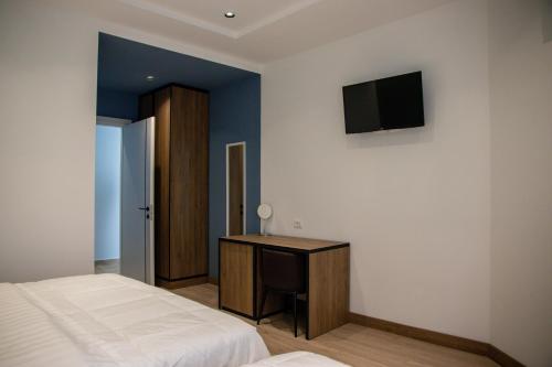 斯库台布里尼酒店的一间卧室配有一张床、一张书桌和一台电视