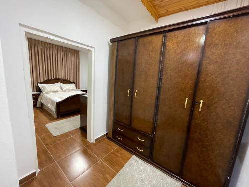 ‘Ayn AmūnAl-Daar的一间卧室配有一张床和一个大型木制橱柜