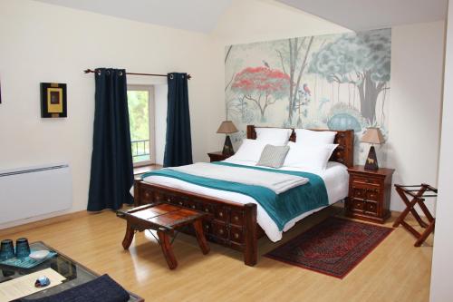 博讷克洛斯查朗特酒店的卧室配有一张大床,墙上挂有绘画作品