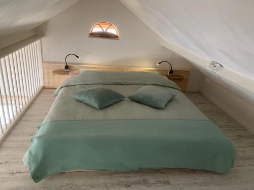 托尔恩B&B Achterom的一间卧室配有一张带两个枕头的大型绿床