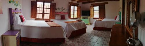 圣克里斯托瓦尔-德拉斯卡萨斯Hotel Tierra Maya的酒店客房设有两张床和电视。