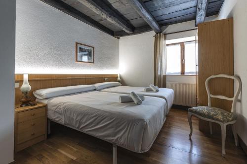EugiHostal Etxeberri的卧室配有床、椅子和窗户。