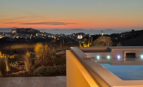 纳克索乔拉Opuntia Suites的日落时分带游泳池的别墅美景