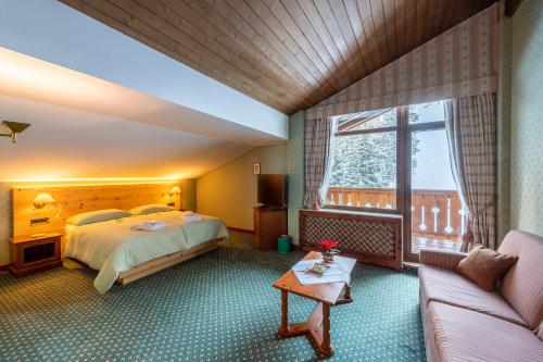 塞尔瓦迪加尔代纳山谷苏切尔斯俱乐部酒店的酒店客房,配有床和沙发