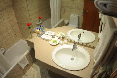 阿布扎比Uptown Hotel Apartments Abu Dhabi by Gewan的浴室配有盥洗盆和浴缸。