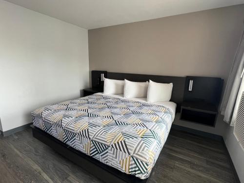 伊利伊利6号汽车旅馆 的一间卧室配有一张带五颜六色棉被的床