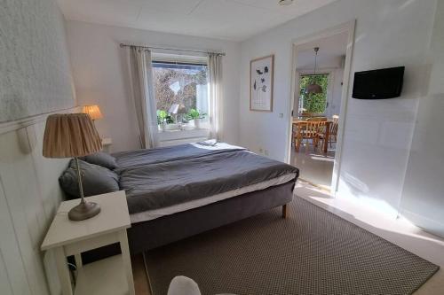 特拉诺斯Trivsamt parhus i lugnt område inne i Tranås!的一间卧室配有床、灯和窗户
