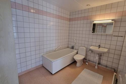 特拉诺斯Trivsamt parhus i lugnt område inne i Tranås!的带浴缸、卫生间和盥洗盆的浴室
