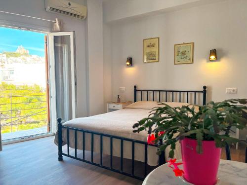 埃尔莫波利斯派卡科亚公园酒店的一间卧室配有一张床和盆栽植物