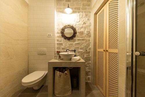 兹曼Tilagus holiday villa - Perla的一间带水槽、卫生间和镜子的浴室