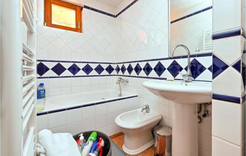 Cozy Home In Ribnjacka With Kitchen的浴室配有盥洗盆、卫生间和浴缸。