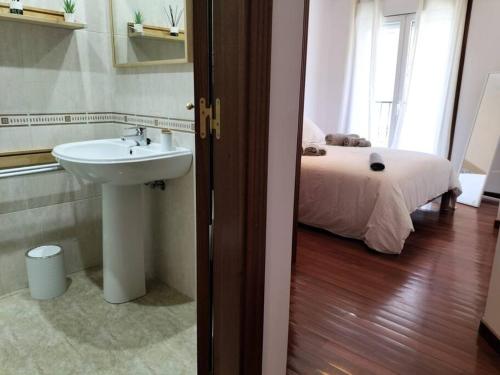 里贝拉Precioso apartamento renovado的一间带水槽的浴室和一张位于客房内的床
