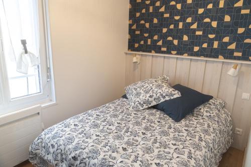 滨海图维列Le BAC FLEURI的一间卧室配有一张带被子和枕头的床