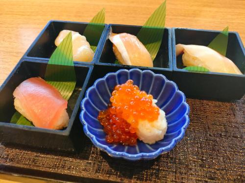 东京多美迎东京八丁堀酒店的盘子上放着一碗酱汁的寿司