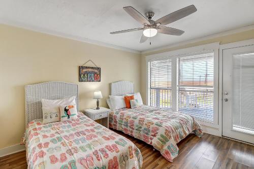 马士腾海滩Latitude Adjustment MIBC201的一间卧室配有两张床和吊扇