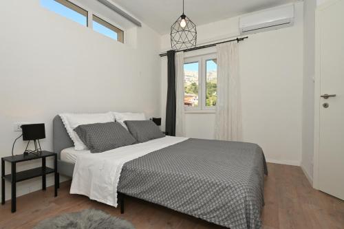 斯林Apartment Relax near Split with Jacuzzi的白色的卧室设有床和窗户