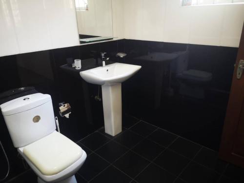 本托塔Sithu Guesthouse的浴室配有白色卫生间和盥洗盆。
