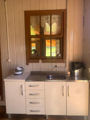 乌鲁佩马Sítio Rota das Araucárias的厨房设有水槽和窗户。