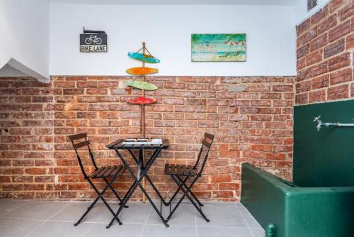 菲盖拉-达福什Beach House City的砖墙边的桌子和两把椅子