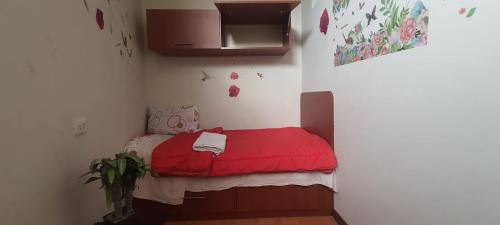 万卡约Apartamento Acogedor的小房间,角落里设有一张红色的床