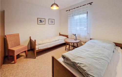 塔尔方Ferienhaus 5 In Thalfang的卧室配有1张床、1张桌子和1把椅子