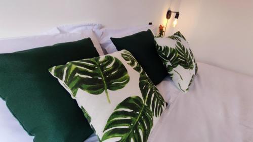 戈亚斯州上帕莱索Villa da Serra的一张带四个绿色枕头的白色床