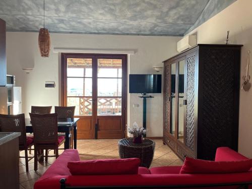 特拉西梅诺湖畔托罗安妮巴乐农家乐的客厅配有红色的沙发和桌子