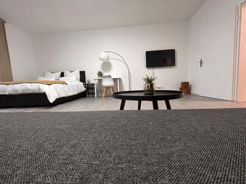 克雷费尔德Europa Apartments nähe Düsseldorf Messe, Airport的一间卧室配有一张床、一张桌子和一台电视。