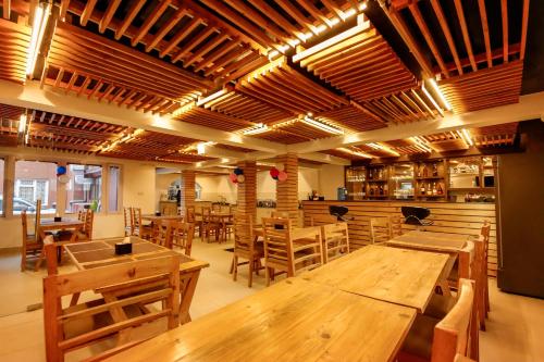 加德满都Hotel Elegant Kathmandu Inn的餐厅设有木桌和木椅