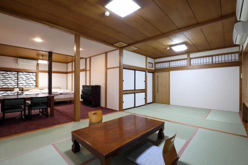 鹤冈市雅司旅馆的带桌子的房间和配有床的房间
