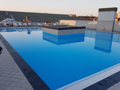 博洛尼亚Your Comfort Home - Bologna的一座建筑物顶部的游泳池,上面有蓝色的灯光