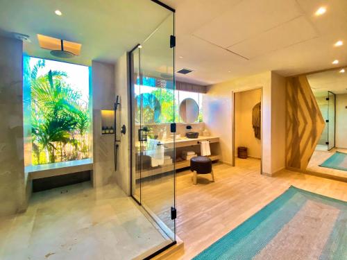 图卢姆Hotel Shibari - Restaurant & Cenote Club的一间带玻璃淋浴的浴室和一张书桌