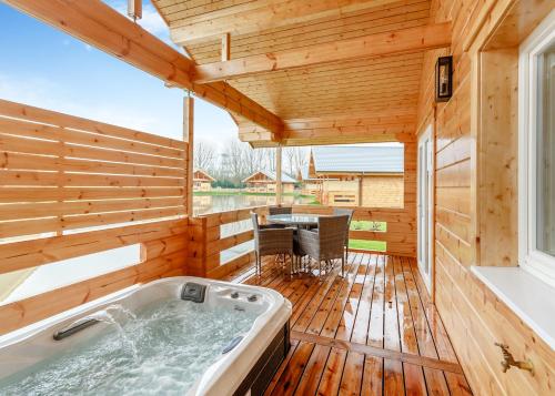 约克Holly Tree Lodges的木制甲板上的按摩浴缸