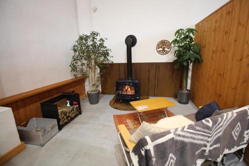 SekiwakiRoots inawashiro Lake Area的客厅的角落里设有燃木火炉