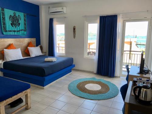 纳闽巴霍蔚蓝海洋酒店的一间蓝色的卧室,配有床和客厅