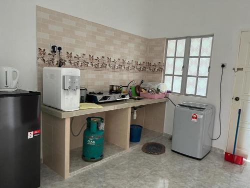 珍南海滩Safiyya Homestay的厨房配有微波炉和冰箱。