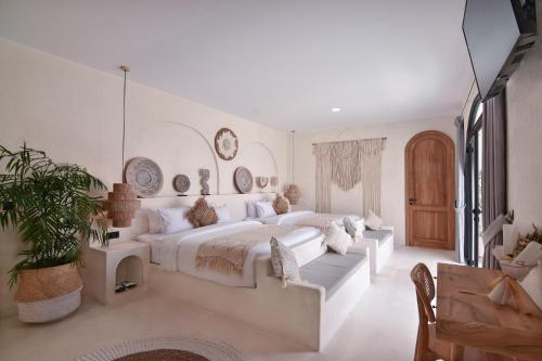 科贾扬Bohemian Jogja Villas with Private Pool的白色卧室设有一张大床和一张沙发
