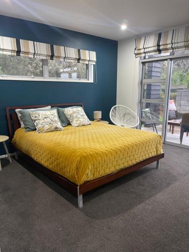 坎布里奇Titoki Grove的一间卧室配有一张黄色毯子床