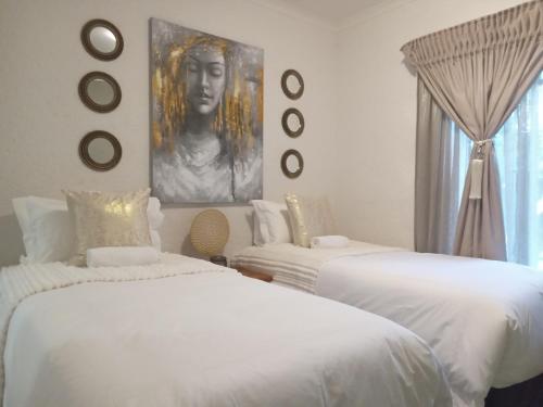 内尔斯普雷特Endonini House的一间带两张床的卧室和一张女人的肖像