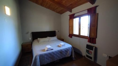 塔菲德尔瓦勒Casa en Tafí del Valle的一间卧室配有一张床,上面有两条毛巾