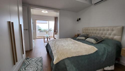 罗萨斯Mediterranean apartment Rosas的一间卧室配有一张带绿色棉被的大床