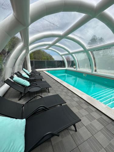 沙安Sandal的一个带躺椅的游泳池和一个带屋顶的建筑