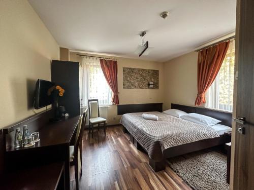 热舒夫梅什科酒店的一间卧室配有一张床、一张书桌和窗户。