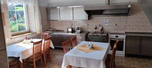 斯托尼拉斯奇Wpadnij do Zosi - ex Pensjonat Emilia的厨房配有2张桌子和椅子以及炉灶。