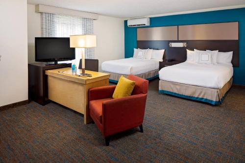樱桃山费城樱桃山原住客栈的酒店客房设有两张床、一把椅子和电视。