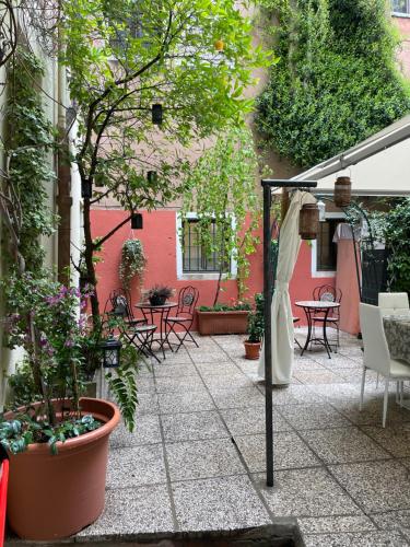威尼斯Hotel Apostoli Garden的户外庭院设有桌椅和植物
