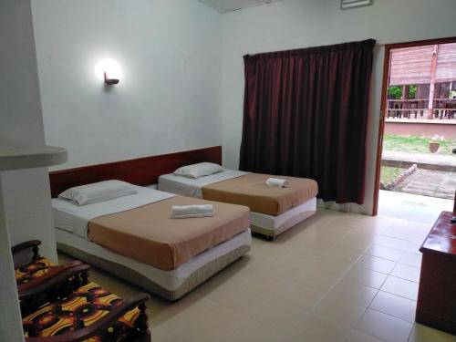 瓜拉丁加奴Seri Indah Resort的带窗户的客房内的两张床