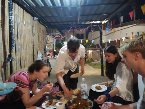 拜县Topp paiway hostel的一群人站在桌子旁吃食物