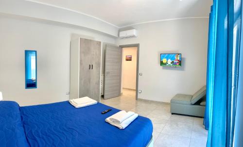 那不勒斯Apartment NAPOLI MARADONA的一间卧室配有蓝色的床和蓝色的沙发