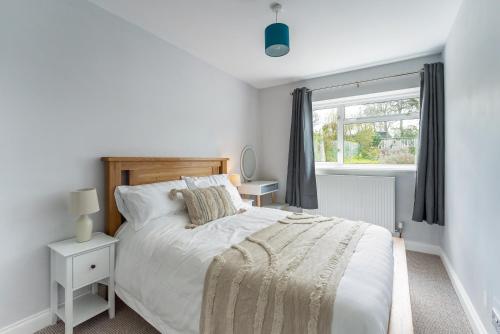 查尔伯里Quiet Cotswold Bungalow的白色的卧室设有床和窗户